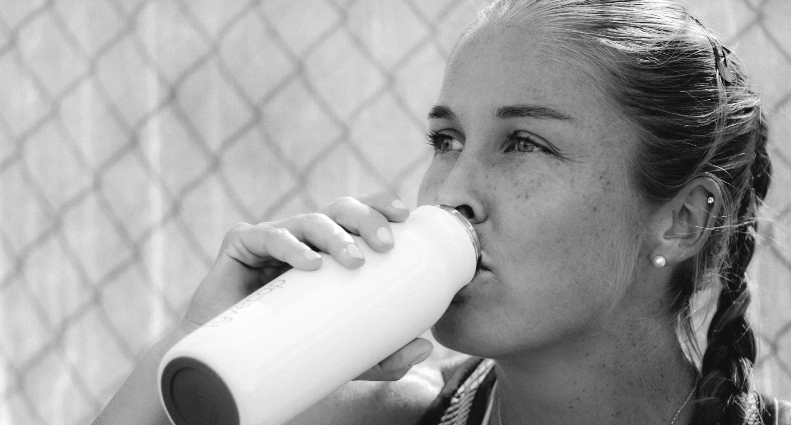 a photo of shelby rogers drinking her Lyvecap probiotics from a white Lyvecap bottle as she focusing on gut health and athletic performance. 